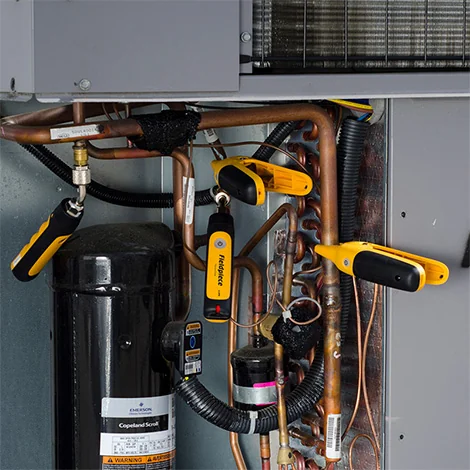 Two Fieldpiece wireless pressure probes and two temperature clamps connected inside an HVAC unit