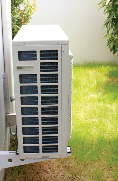 Daikin FIT outdoor unit wall-mounted beside a home