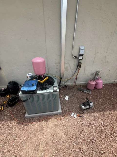 Outdoor HVAC unit during service with tools and hoses