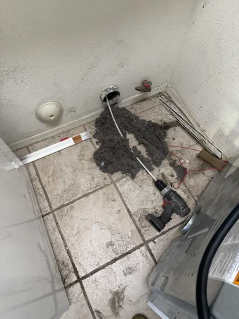 An exposed wall connection and floor area documented during equipment work.