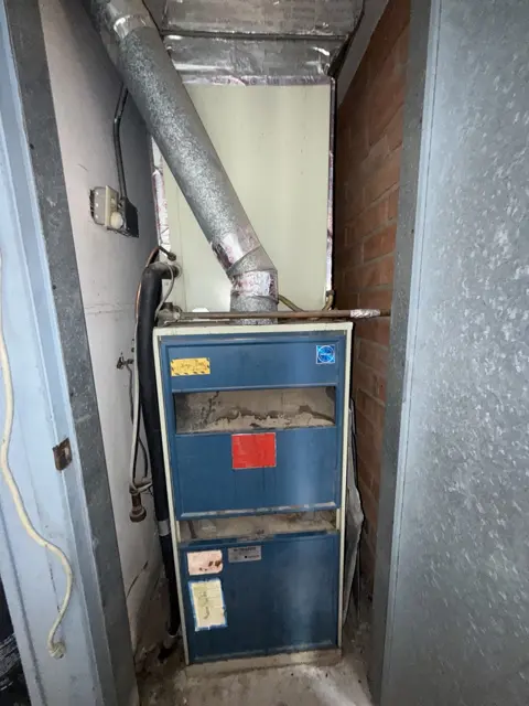 An existing furnace and metal vent connection photographed during a service visit.