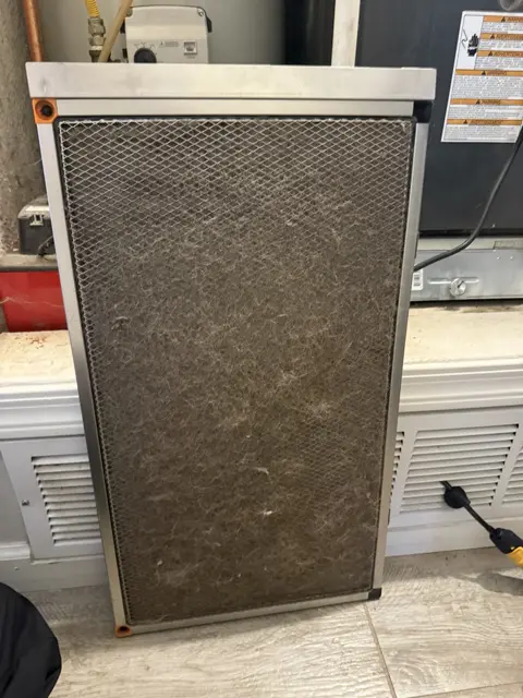 A dust-covered filter removed from HVAC equipment during service.