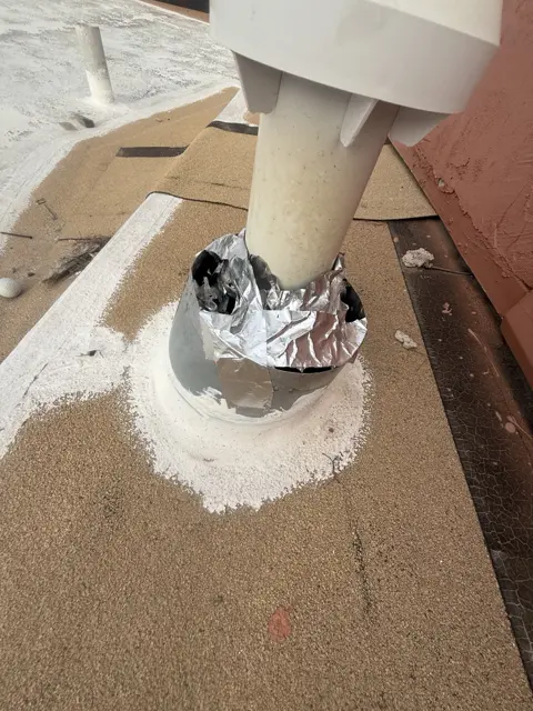 A close-up of a pipe penetration and surrounding roof surface.