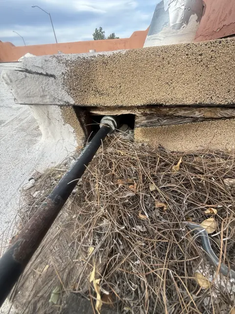 An opening near the roofline with visible debris, documented during a visit.