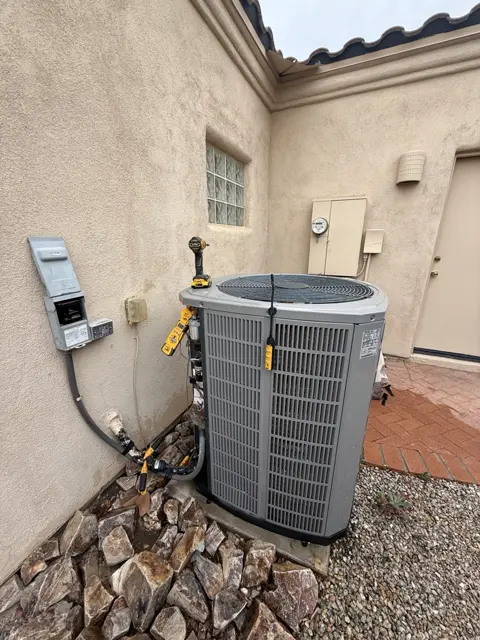 An outdoor condenser with hoses and connections visible during service.