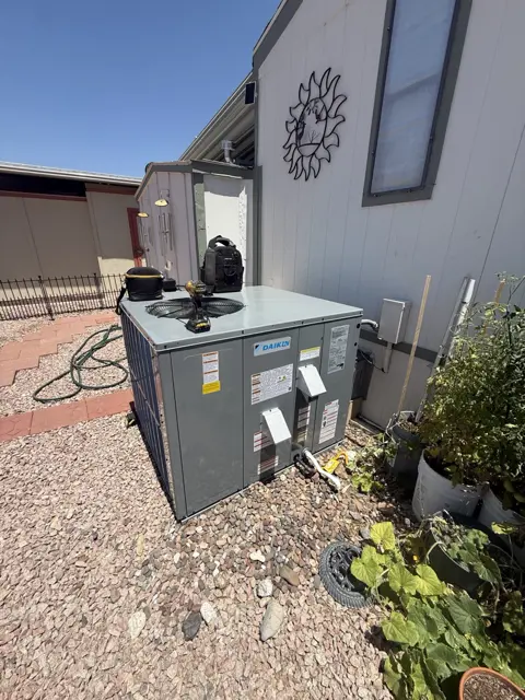 A ground-level packaged HVAC unit beside a Tucson-area home.