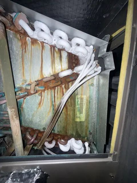 Coil surfaces and refrigerant tubing photographed during an HVAC service visit.