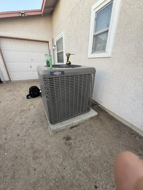 An outdoor condenser with service equipment nearby.