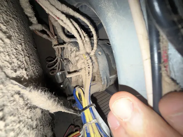 Dust and debris visible inside an open HVAC blower compartment during service.
