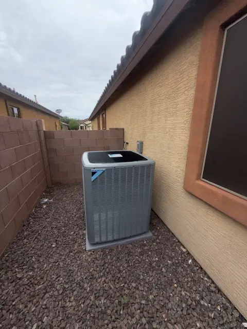 An outdoor HVAC unit in the side yard of a Tucson-area property.