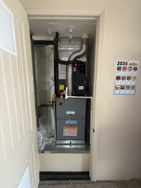 An upright furnace and its visible vent and drain connections.