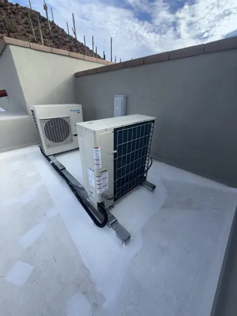 Two compact outdoor HVAC units on a flat roof.