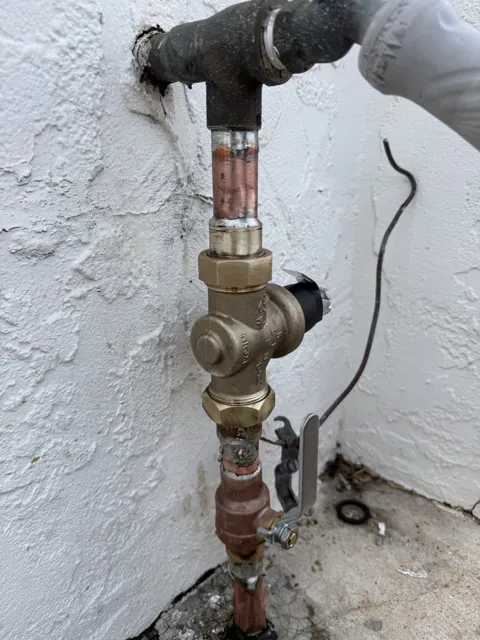 Exterior water supply piping with a pressure regulator and shutoff valve
